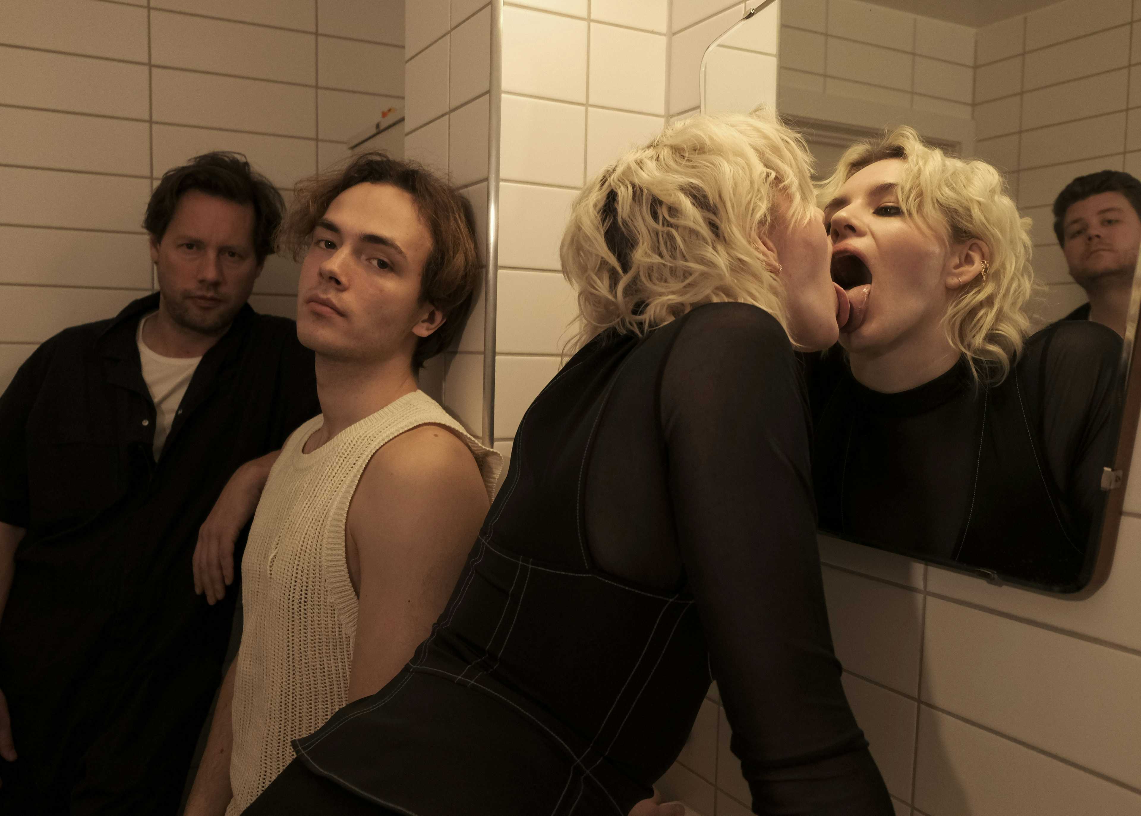 Foto av trioen Das Body, der vokalisten slikker på speilet